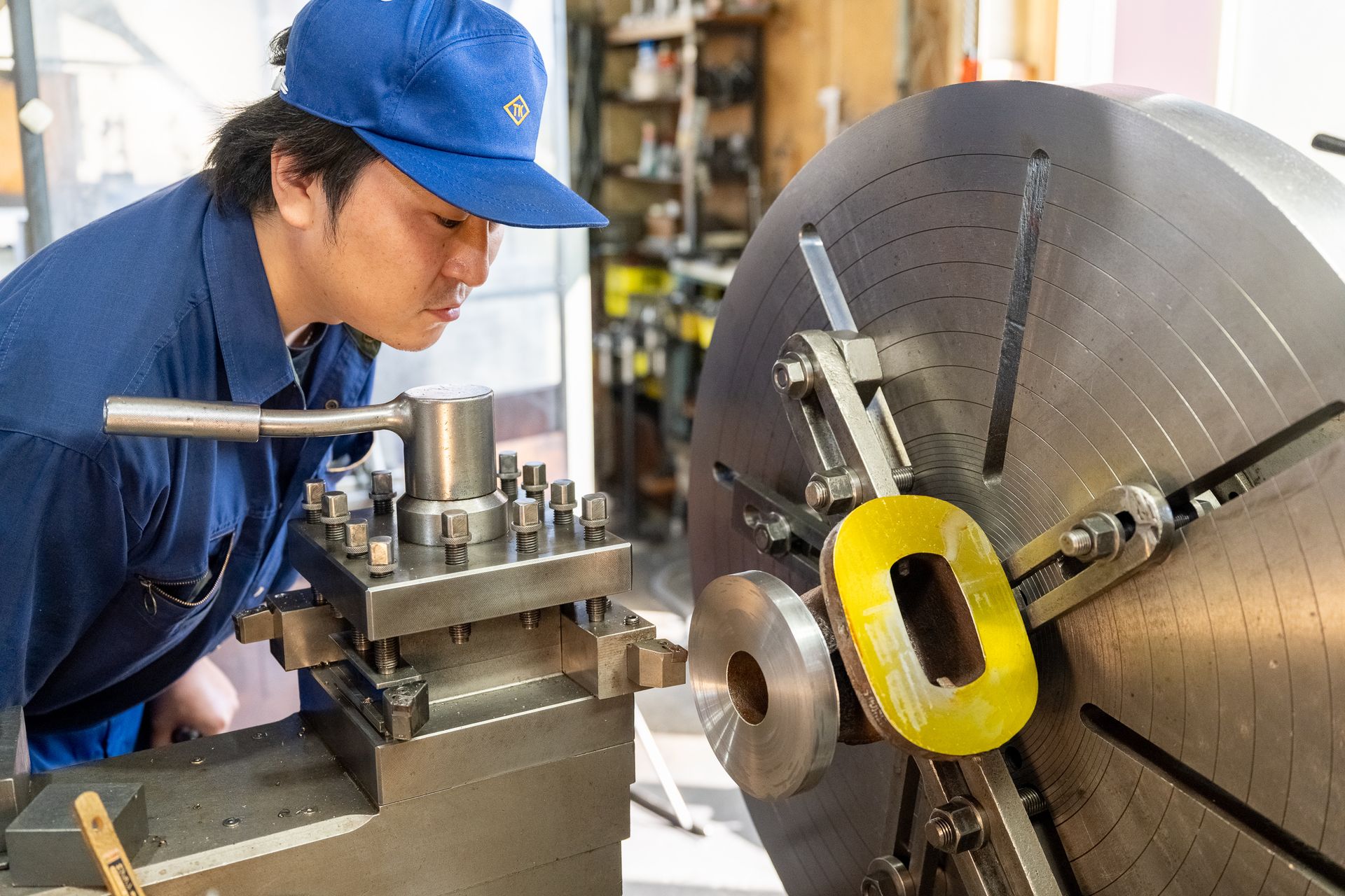 旋盤で加工面を見つめる技術者